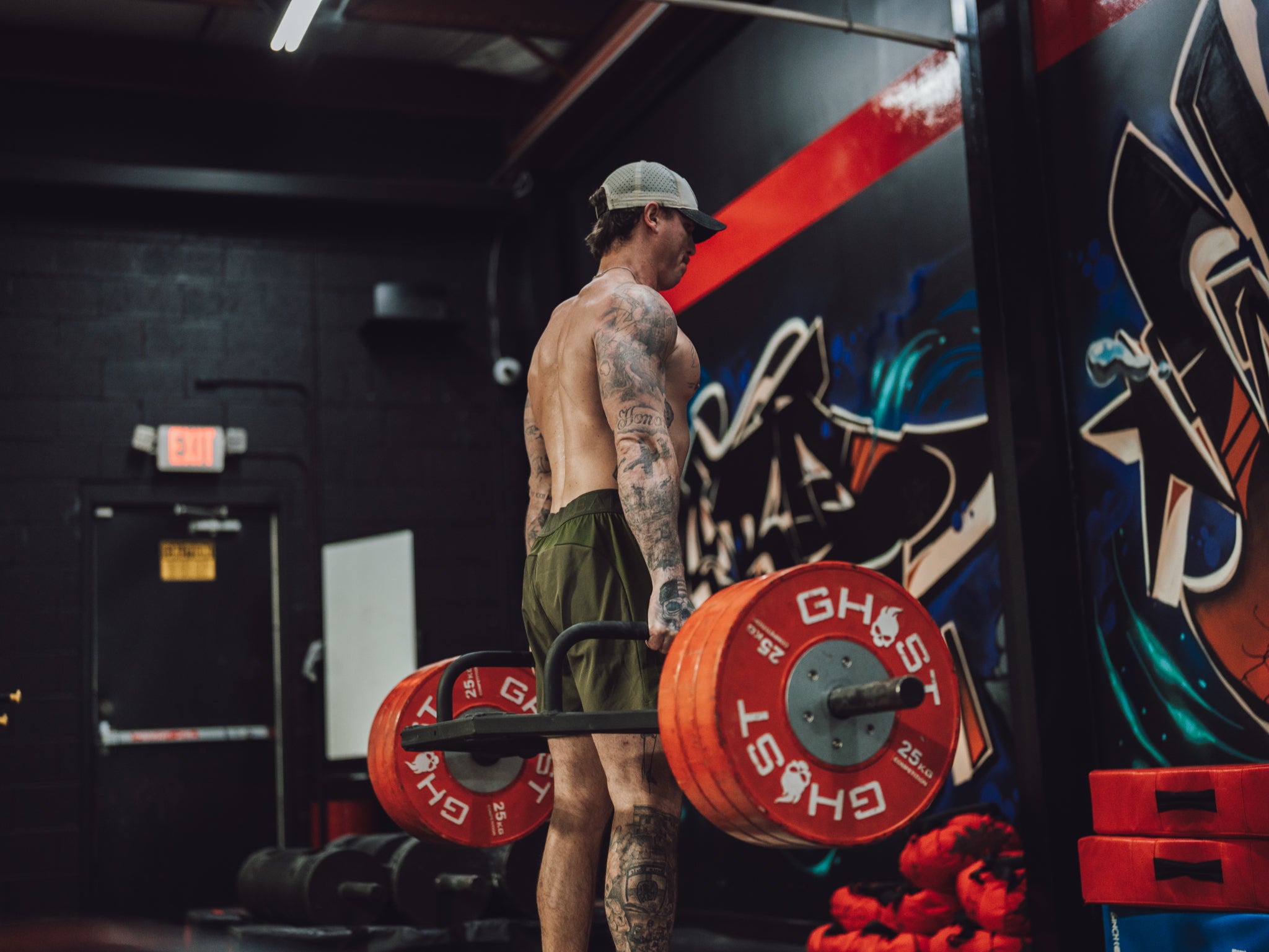 Between sets on the gym floor in the Jungle Moss Motto Short