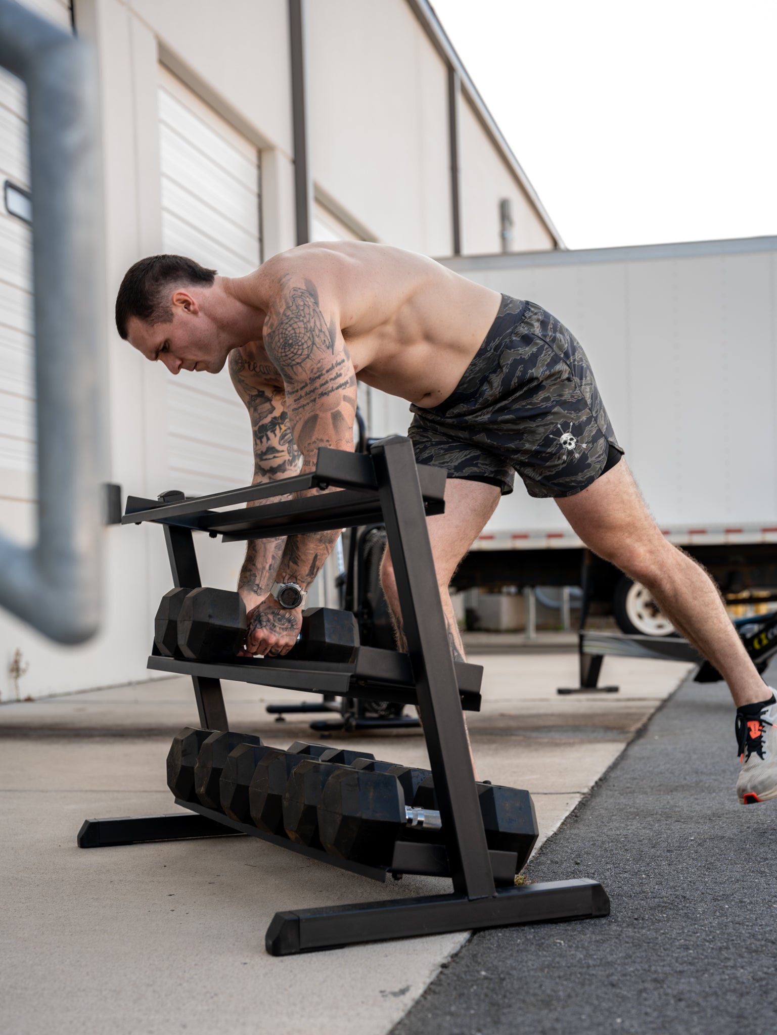 Pulling dumbbells off the rack in the Deep Forest Hybrid Short