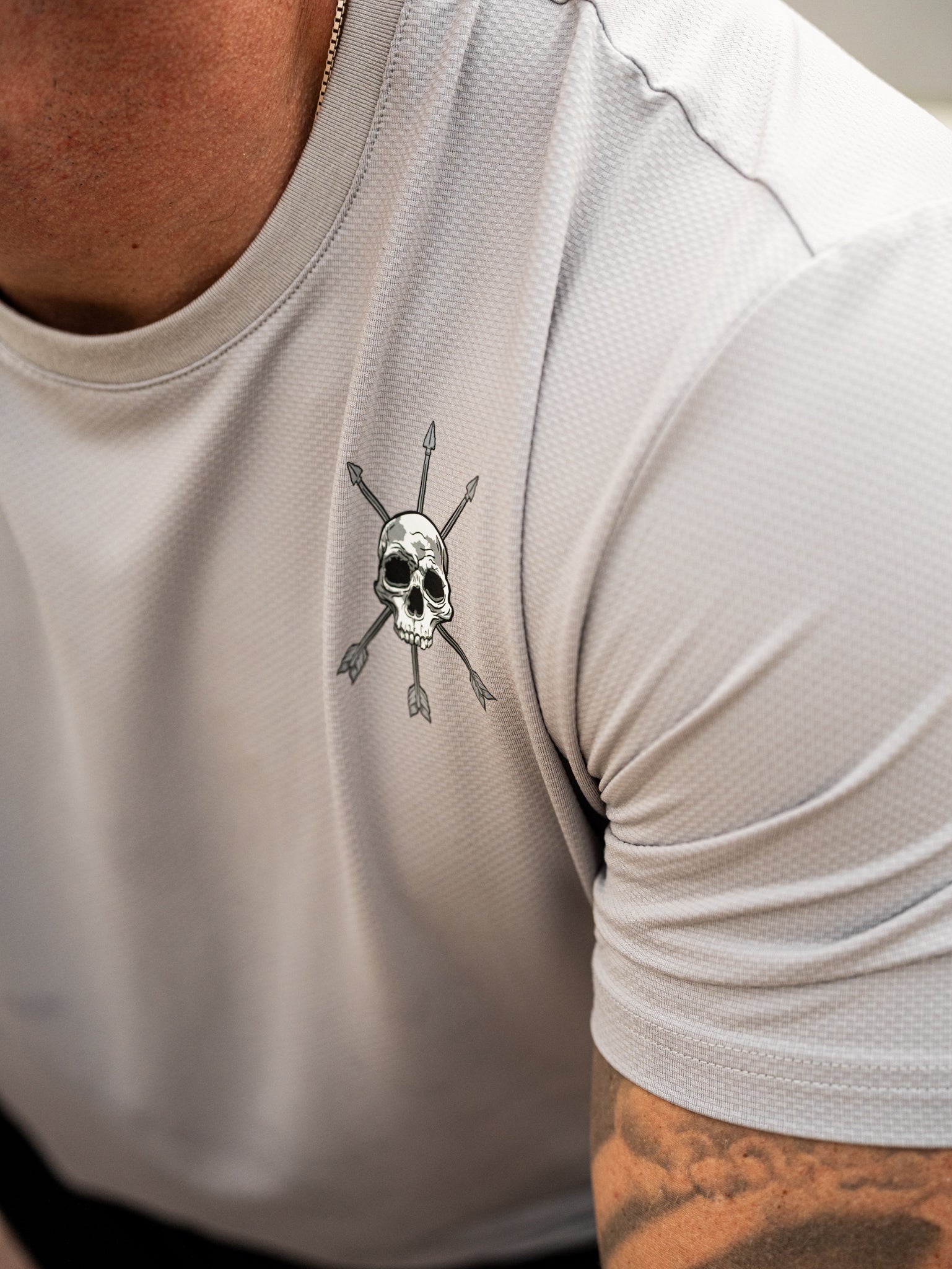 The skull and arrows mark close up on the Ascend Tee