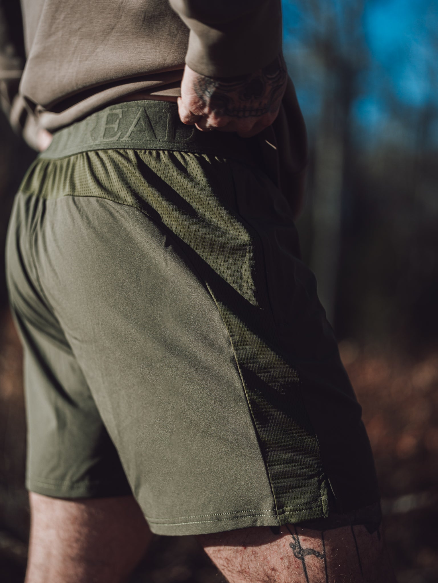 Jungle Moss Motto Short in daylight, mesh side panel and inner waistband